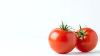 Fresh red tomatoes with green stems isolated on white background for healthy cooking and organic food concepts.