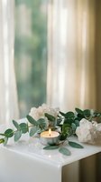 Spa wellness setup with eucalyptus branches, lit candle and white crystals on table creating peaceful meditation atmosphere for relaxation and mindfulness.