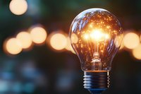Glowing light bulb with warm bokeh background creates magical atmosphere, symbolizing innovation, creativity and bright ideas for business concepts.