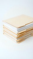 Stacked notebooks with cream and gold covers isolated on white background, ready for design mockups, branding, and stationery projects.