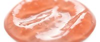 Translucent coral gel or serum with flowing liquid texture and glossy finish on white background, suitable for cosmetics, skincare, beauty product packaging, and wellness marketing materials.