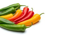 Fresh colorful chili peppers in red, yellow and green varieties isolated on white background for cooking and spice ingredient designs.