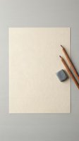 Blank textured paper sheet with wooden pencils and eraser on neutral background for creative projects and artistic work.