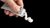 Hand squeezing toothpaste tube with white paste dispensing out, isolated on transparent background. Ready for dental care, hygiene, and oral health design projects, t-shirts, clipart, and print-on-demand products.