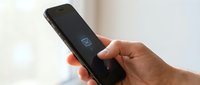 Hand holding smartphone with low battery warning icon on screen showing power depletion and need for charging in modern minimalist setting.