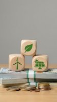 Wooden blocks with green renewable energy icons stacked on banknotes and coins, symbolizing sustainable investment and eco-friendly financial growth for business concepts.