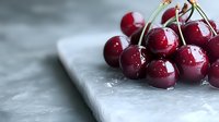 Fresh ripe cherries with water drops on white marble surface. Close up view of juicy dark red sweet cherries with stems for food photography and design.