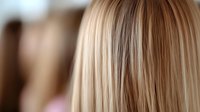 Close-up of blonde hair strands showing natural highlights and lowlights with smooth silky texture for beauty and haircare concepts.