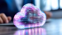 Glowing digital cloud with pink and blue neon light effects on desk surface, representing cloud computing technology and data storage solutions.