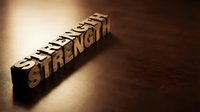 Wooden letter blocks spelling STRENGTH on dark surface with dramatic lighting for motivation and empowerment concepts in business and personal development.