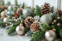 Festive arrangement with frosted pine cones, mint green and champagne ornaments, evergreen branches and metallic accents on light background. Holiday decor composition.