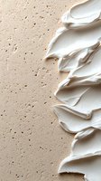 Smooth white cream texture swirls against beige textured background creating abstract waves pattern. Cosmetic product background for beauty and skincare marketing.