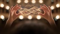 Two hands holding glowing golden light energy between palms against blurred bokeh background, representing magic, power, healing, spirituality, and mystical energy for wellness and alternative medicine concepts.