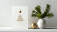 Minimalist Christmas card with gold tree design and star, white vase with pine branches, and gold ornament on neutral background.