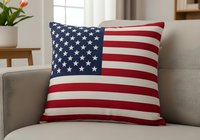 Patriotic flag throw pillow with stars and stripes displayed on neutral sofa, perfect for home decor and seasonal interior design projects.