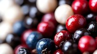 Fresh colorful wooden beads in red, blue, black and natural wood tones arranged in macro composition showing texture and glossy surface detail.