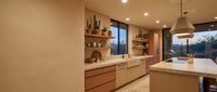 Modern minimalist kitchen interior with wooden cabinets, marble countertops, pendant lighting and open shelving in contemporary home design.