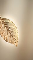 Elegant golden leaf with intricate ornamental patterns on warm beige background for luxury design projects and decorative applications.