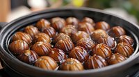 Chocolate truffles with decorative drizzle arranged in black ceramic bowl on wooden surface for gourmet dessert and confectionery presentations.