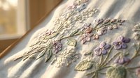Delicate hand embroidered floral design with purple lavender flowers on natural linen fabric in soft sunlight for crafting and textile projects.