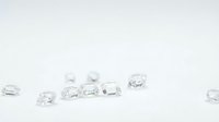 Clear crystal gemstones and faceted glass stones scattered on white background for jewelry design, crafting, and decorative applications.