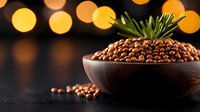 Fresh pine nuts in wooden bowl with rosemary sprig on dark background with golden bokeh lights, raw organic healthy snack for cooking and garnish.