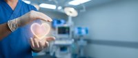 Healthcare professional holding glowing heart symbol in modern hospital operating room representing medical care and cardiology services.