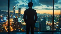 Silhouette of businessman contemplating urban cityscape with illuminated skyscrapers and dramatic sunset sky through panoramic office window. Modern metropolis view.
