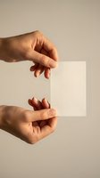 Two hands holding transparent glass square panel against neutral beige background with soft natural lighting and shadow effects for modern design projects.