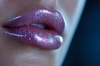 Close up of sensual lips with shimmering pink glitter makeup in soft lighting, showing glamorous cosmetic application and professional beauty artistry.