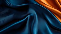 Luxurious dark blue and orange silk fabric with elegant folds and waves creating dramatic contrast. Smooth textile background for fashion and design projects.