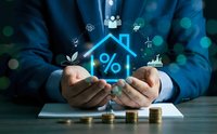 Businessman hands protecting glowing house with percentage symbol and renewable energy icons for mortgage rates and sustainable home financing solutions.