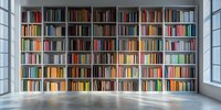 Modern library interior with white built-in bookshelves spanning wall to wall, filled with colorful books, natural light streaming through windows onto polished concrete floor.