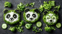 Creative food art with panda faces made from rice, seaweed, cucumber slices, and fresh green vegetables arranged on dark background. Fun kids meal concept.