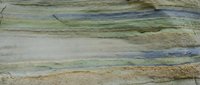 Natural stone texture with horizontal layers in beige, gray and green tones creating organic striped pattern for interior design and architectural projects.