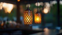 Glowing decorative pendant lamps with geometric pattern casting warm light in evening restaurant atmosphere. Cozy interior lighting design creates ambiance.