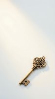 Ornate golden vintage key with decorative crown head lying on clean white surface for luxury branding and security concepts.
