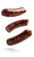 Flying grilled dark sausages isolated on white background. Levitating smoked meat products with natural casing for food industry and menu design.
