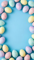 Colorful pastel Easter eggs arranged as a border frame on a light blue background with copy space for text or design.