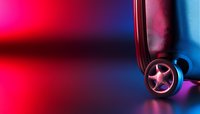 Stylish wheel on dark background with vibrant neon pink and blue gradient lighting creates dramatic atmosphere for automotive and technology concepts.