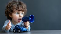 Young curly-haired boy with bright blue eyes shows excitement while playing with blue toy megaphone and car against dark background, expressing joy and wonder.