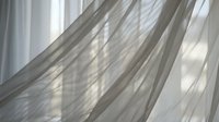 Sheer curtains with soft sunlight streaming through, creating delicate shadows and light patterns on white fabric for home decor and interior design.