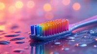 Colorful toothbrush with rainbow bristles on wet surface with water drops and pink bokeh lights background creating dreamy dental hygiene concept.