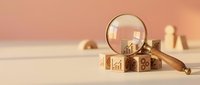 Wooden alphabet blocks with magnifying glass on neutral background for educational learning and child development concepts.