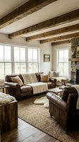 Rustic living room interior with exposed wooden ceiling beams, leather furniture, stone fireplace and large windows showcasing countryside views.