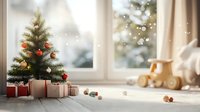 Small decorated Christmas tree on windowsill with wrapped presents beneath, wooden toy train and soft bokeh snow effect creates cozy holiday atmosphere.