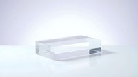 Clear acrylic rectangular block on white surface, transparent glass-like pedestal for product display, modern minimalist podium for cosmetics showcase.