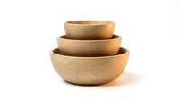 Stacked wooden bowls in natural light, isolated on white background. Suitable for kitchenware, home decor, and tableware design projects.