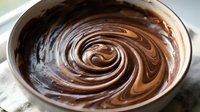 Melted chocolate swirl in mixing bowl, ready for baking, dessert preparation, and confectionery cooking projects.