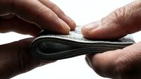 Empty wallet held open by male hands with dark skin tone, showing no money inside, symbolizing financial hardship, poverty, bankruptcy, or lack of funds for business, personal finance, or economic crisis concepts.